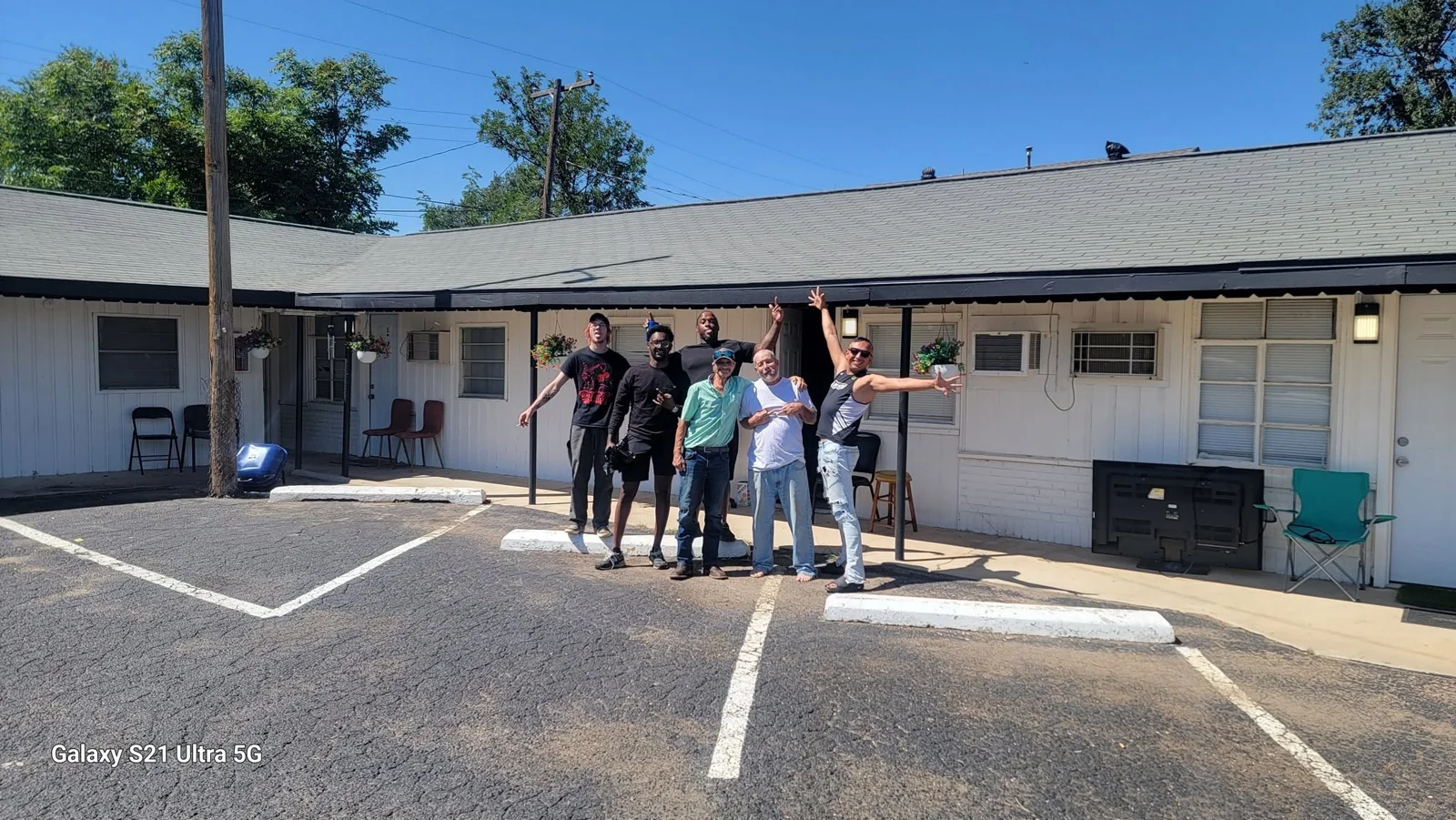 A group from the Bridging the Gaps community celebrating together outside a housing building